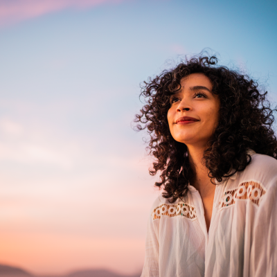 Smiling person before a colourful sky