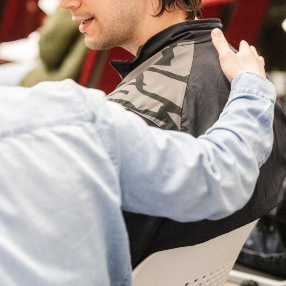 Two clients sitting together, the one giving the other a pat on the back