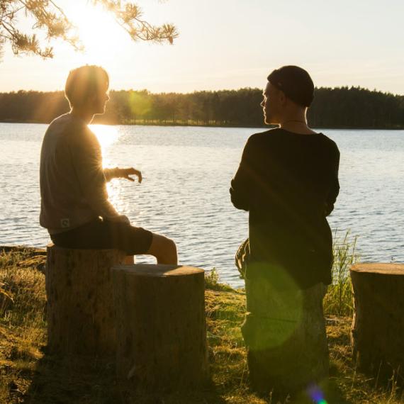 Two people talking by water
